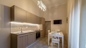 Een moderne keuken met een ingebouwde kookplaat, gootsteen en een eethoek met een tafel en stoelen.