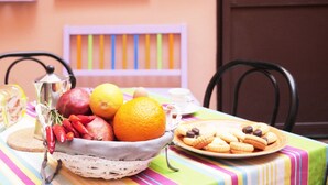 Een tafel met een fruitschaal, een bord koekjes en een strepen tafelkleed.