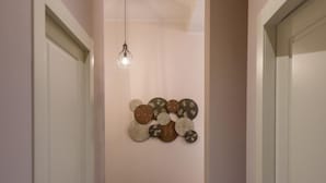 Un couloir doté d’un sol en marbre, d’un luminaire fixé au mur et d’une œuvre d’art décorative.