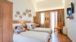 Een hotelkamer met twee bedden, een televisie, een stoel en decoratieve wandkunst.