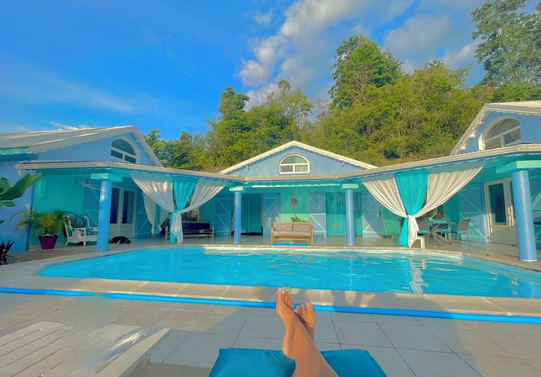 Une piscine avec vue sur une maison et des arbres.