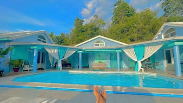 Une piscine avec vue sur une maison et des arbres.