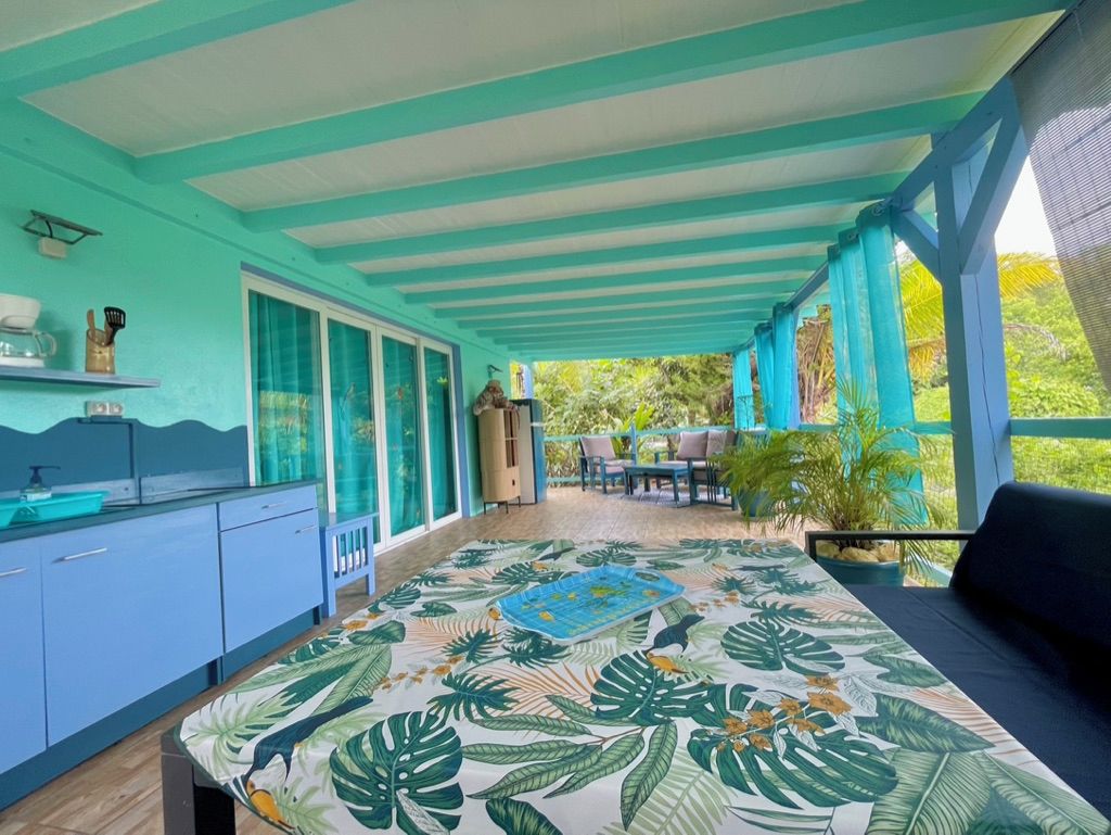 Une chambre avec un lit, une petite kitchenette, un coin repas et une vue sur la verdure.