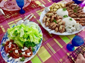 Une table avec deux assiettes de nourriture, l’une contenant une salade et l’autre du riz et des crevettes.