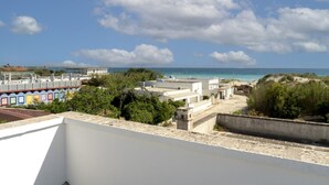 Küstenansicht mit Gebäuden, einem Strand und einem klaren Himmel.