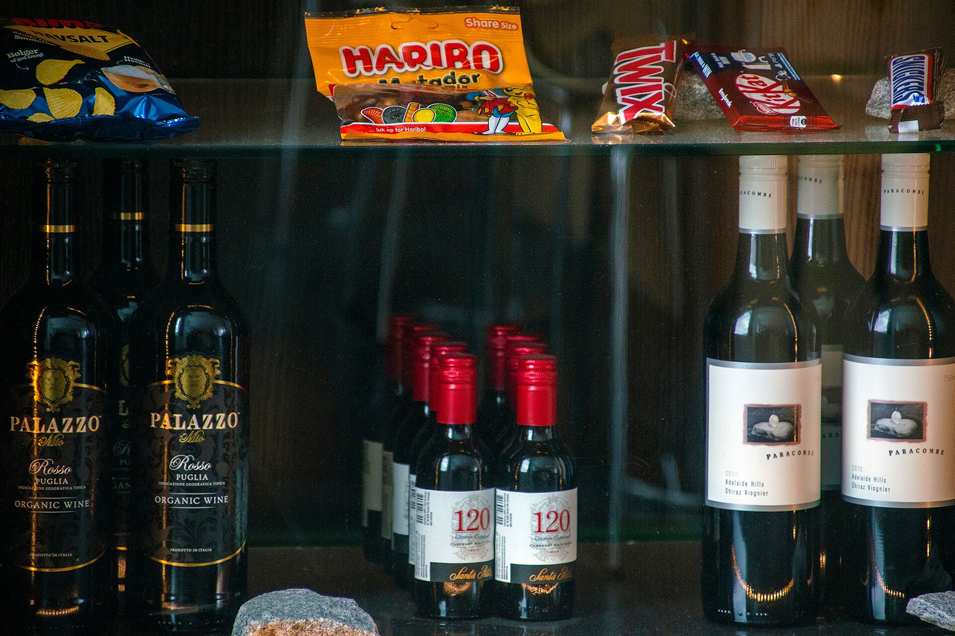 Bottles of organic wine and snacks on a shelf.