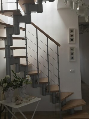 A modern staircase with a minimalist design, featuring a combination of wooden steps and metal railings.