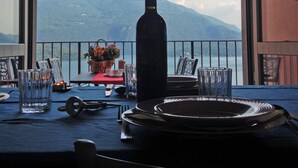 Une table dressée pour le dîner, avec vue sur une montagne et un lac.