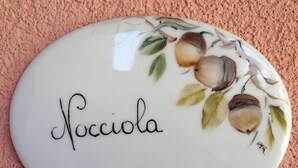 Une assiette en céramique portant le nom « Nocciola » et ornée d’un motif floral.