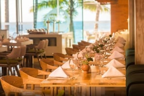 A restaurant with wooden tables and chairs, set for dining with wine glasses and napkins.