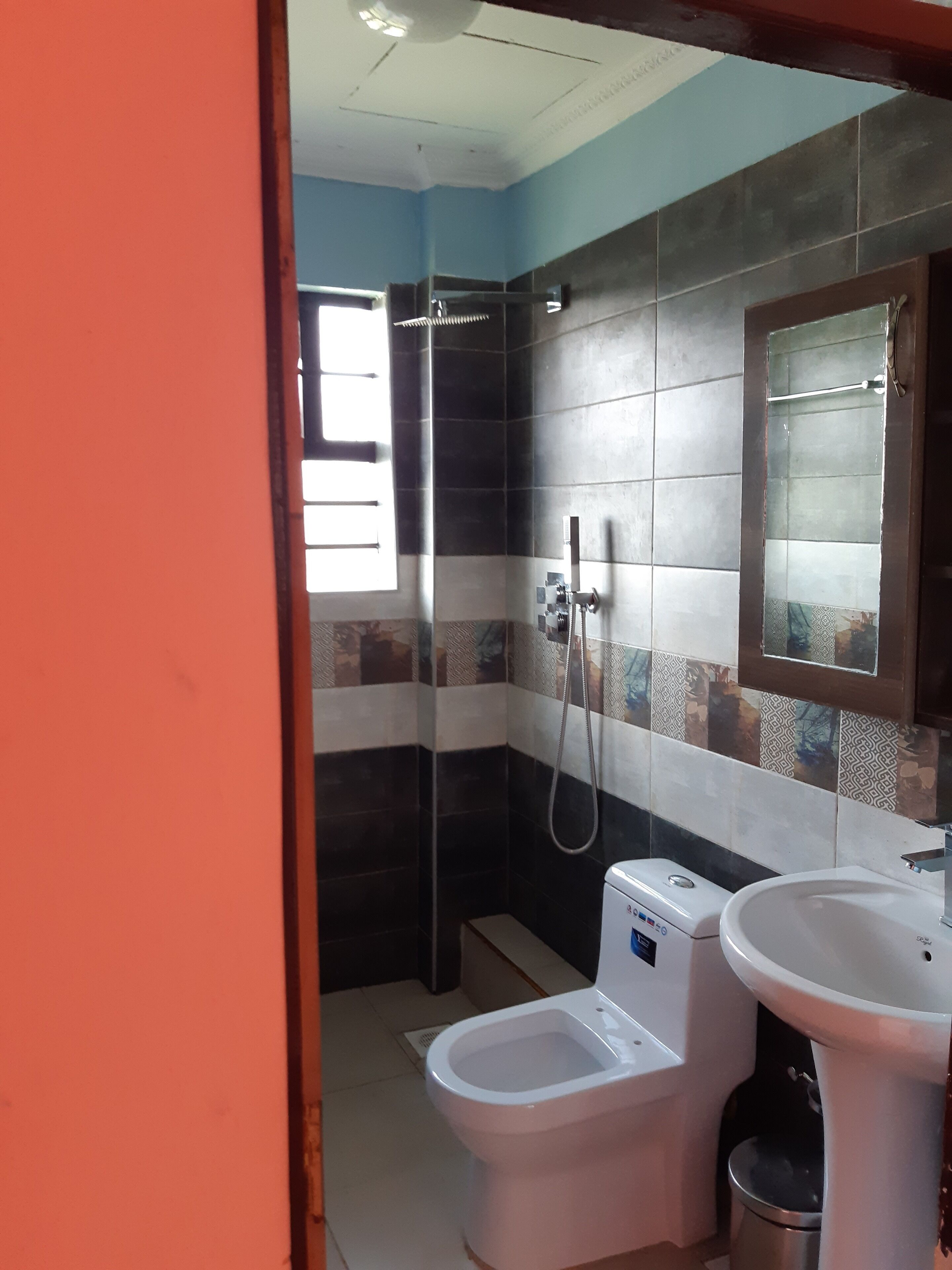 A bathroom with a shower, toilet, and sink.