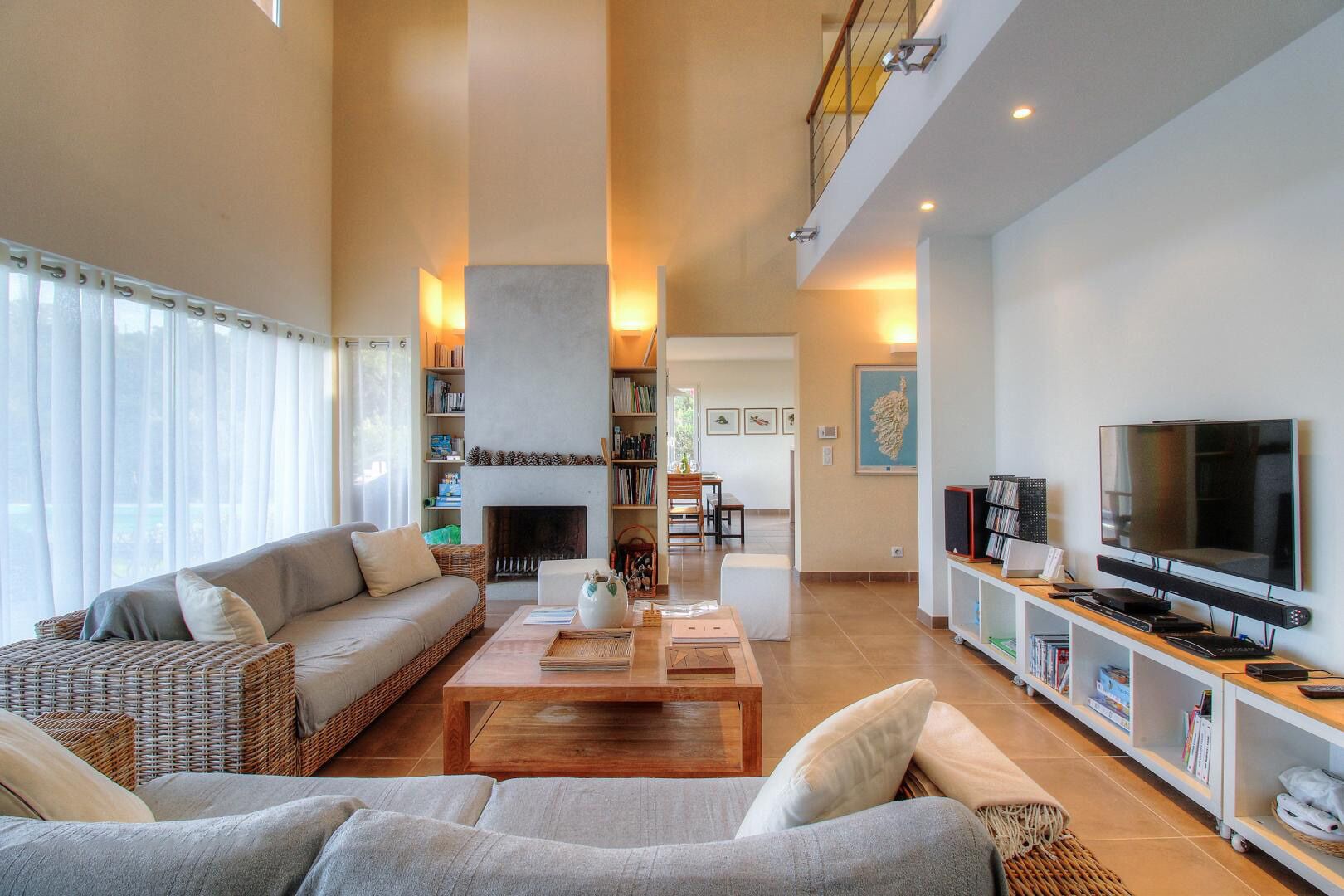 A spacious living room with a fireplace, a sofa, a coffee table, and a TV.