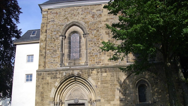 A stone building with a large arched entrance and a smaller arched window above it. - Messewohnung Gräfrath (Solingen)