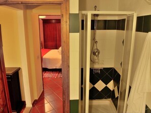 A hotel room with a shower, a bed, and a red carpeted hallway. - I Colombi 2+2 p - Comfortable apartment in Organic Agriturismo, air conditioning (Montescudaio)