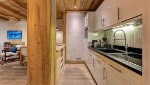 Una cocina moderna con vigas de madera, una isla grande y vistas a las montañas.
