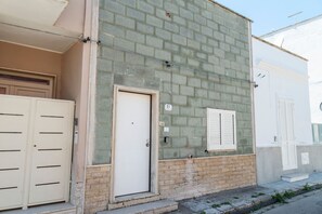 A building with a beige door, a number '51' sign, and a window with shutters.
