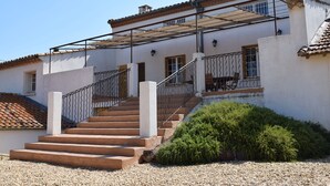 Un bâtiment doté d’un escalier menant à une zone abritée, protégée par une rambarde en métal.