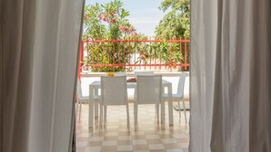 An outdoor seating area with white chairs and a table, a red fence, and greenery in the background. - Holiday house in Torre Lapillo beach (TL23) (Torre Lapillo)