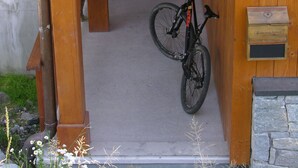 Un bâtiment en bois avec une enseigne indiquant « Les Lumelles ». Un vélo est garé devant.