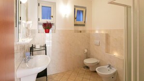 Une salle de bain équipée d’un lavabo, d’un bidet, de toilettes et d’un miroir.