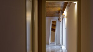 A hallway with a wooden ceiling, a white door frame, and a marble floor. - Apartment Standard Suite  4 (Vasto)