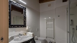 A bathroom with a large mirror, a sink, a toilet, and a shower. - Apartment Standard Suite  4 (Vasto)