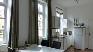 Eine kleine Küche mit Essbereich, inklusive Tisch, Stühlen und Kühlschrank.