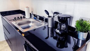 A modern kitchen with a stainless steel sink, a coffee maker, and a kettle. - Loft Aparment Steps From Nightlife, Gladiolas II /Loft + Room /Free WIFI - 2101 (Ponce Pueblo)