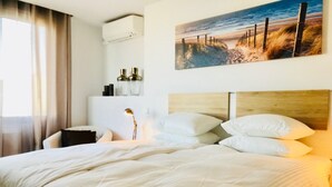 A neatly made bed with white linens, a bedside lamp, and a wall-mounted air conditioner. - Luxurious Penthouse (Atico) ‘La Mar Altea', max. 4p (Altea)