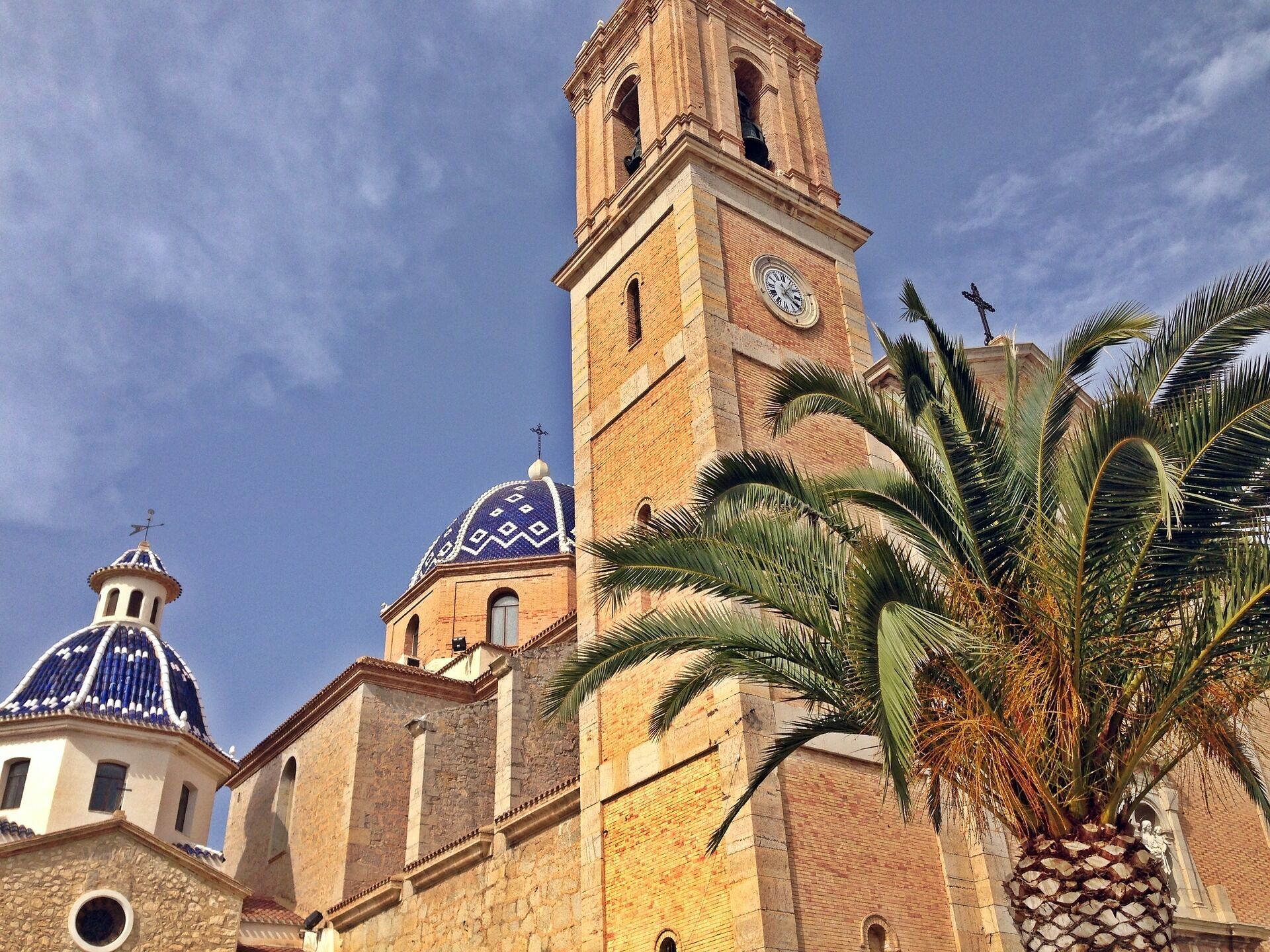A historic building with a prominent clock tower and domed structures.