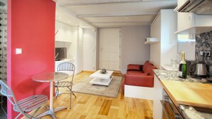 A compact living space with a dining area, a sofa, a small table, and a kitchenette. - THE GARDEN OF THE VILLAGE IN VALBONNE (3 ***): live in-out (Valbonne)