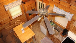 A cabin interior with a dining area, kitchen, and ceiling fan. -  Cherokee Family Cabin  (Hico)