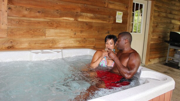A wooden cabin interior with a hot tub. -  Cherokee Family Cabin  (Hico)