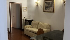 Un comedor con una mesa, sillas, un sofá y un cuadro en la pared.