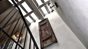 A staircase with a metal railing, a wooden door, and a light fixture. - Charming artist's hideaway with stunning view over Modica (modica)