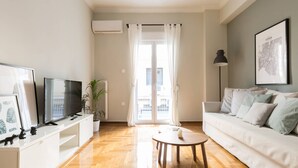 Uma sala de estar moderna com sofá, mesa de centro, televisão e radiador.