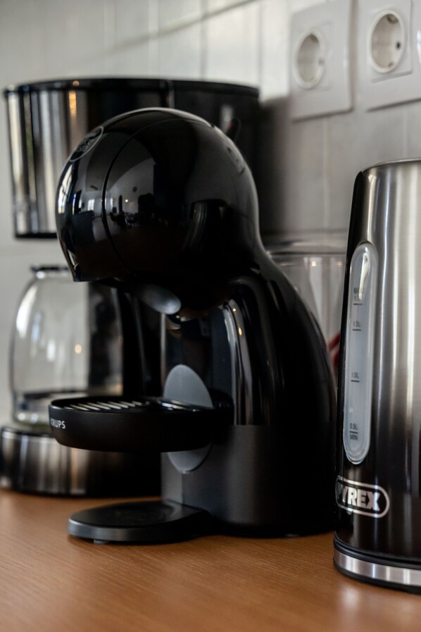 A black coffee machine with a digital display on a kitchen counter.