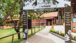 Skilt for Parque Biológico Vinhais, med en sti, der fører til en bygning.