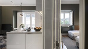Eine moderne Küche mit Kochinsel, Essbereich mit Tisch und Stühlen, Sofa und großem Fenster für natürliches Licht.
