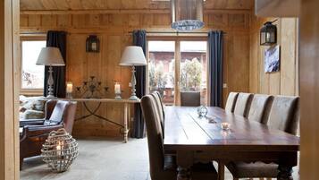 Un interno in legno con un tavolo da pranzo, sedie e un lampadario.