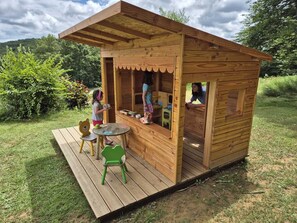 Una casetta in legno con un portico, un tavolino e delle sedie.
