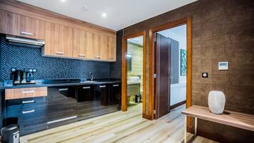A modern kitchen with wooden cabinets, a black countertop, and a wooden bench.