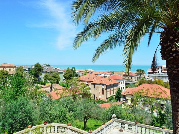 Un quartier résidentiel situé sur la côte, avec des maisons, un ciel dégagé et une vue sur la mer.