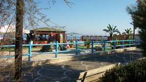 A coastal area with a small kiosk, a blue railing, and potted plants. - Villa BUTTERFLY 1 SEA RELAX AND CLOSE TO CULTURAL SITES (Capaci)