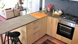 Cocina pequeña con estufa, horno y armarios de madera.