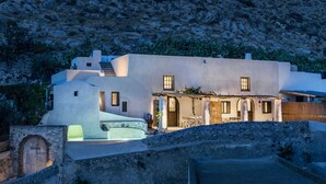 A modern house with a stone facade, a pool, and a patio area.