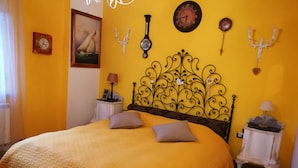 Ein Schlafzimmer mit einem großen Bett, einem dekorativen Kopfteil und mehreren Wanduhren.