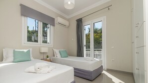 Hotellihuone, jossa on kaksi sänkyä, parveke ja näkymä ulos.