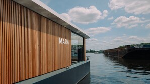 A modern building with a wooden facade and a sign that reads "MARA". - Spreeapartment MARA (Berlin)