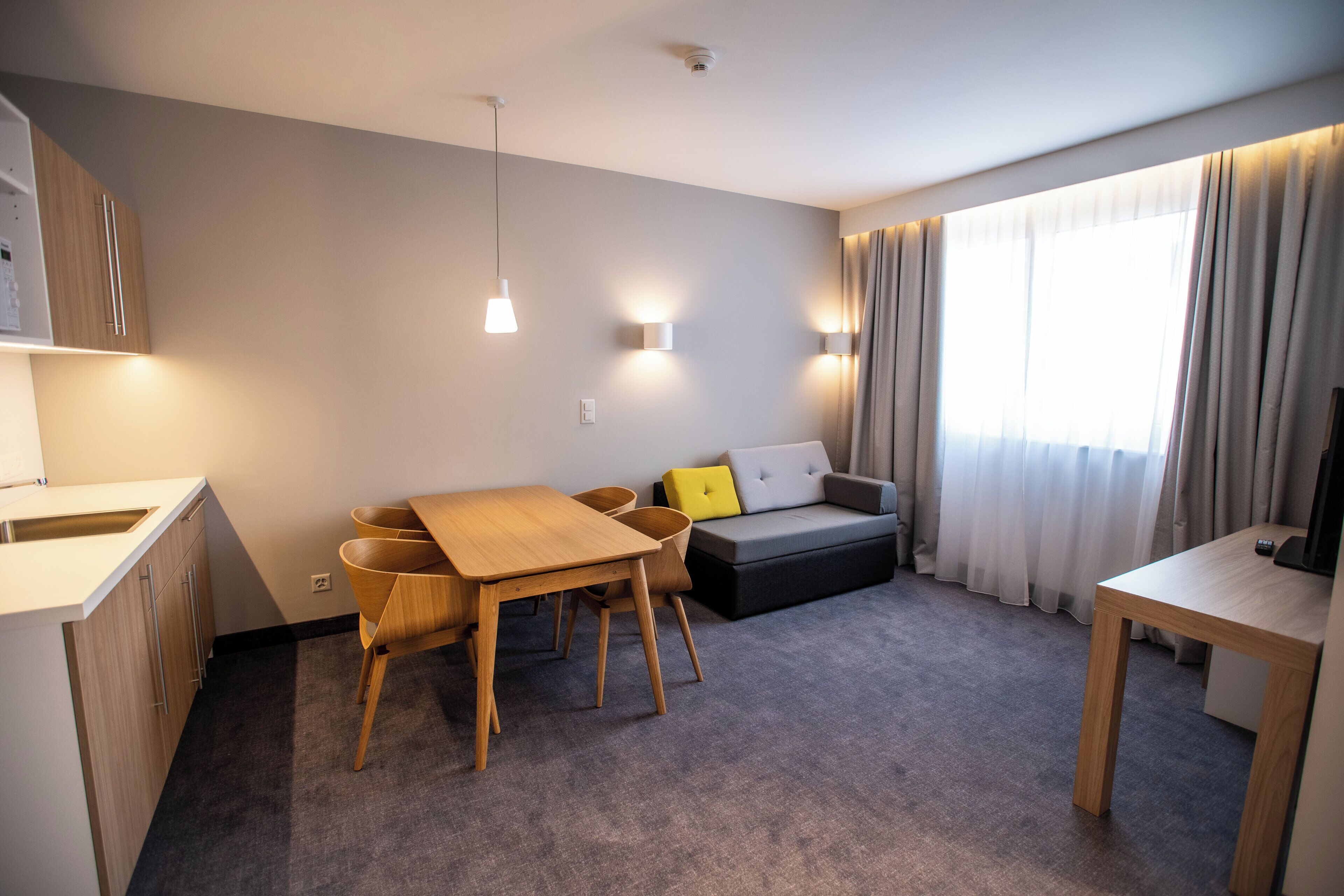 Una sala de estar moderna con un sofá, una mesa de comedor y un televisor.